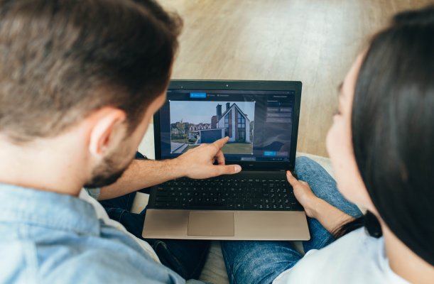 Two people looking at housing plans on a tablet